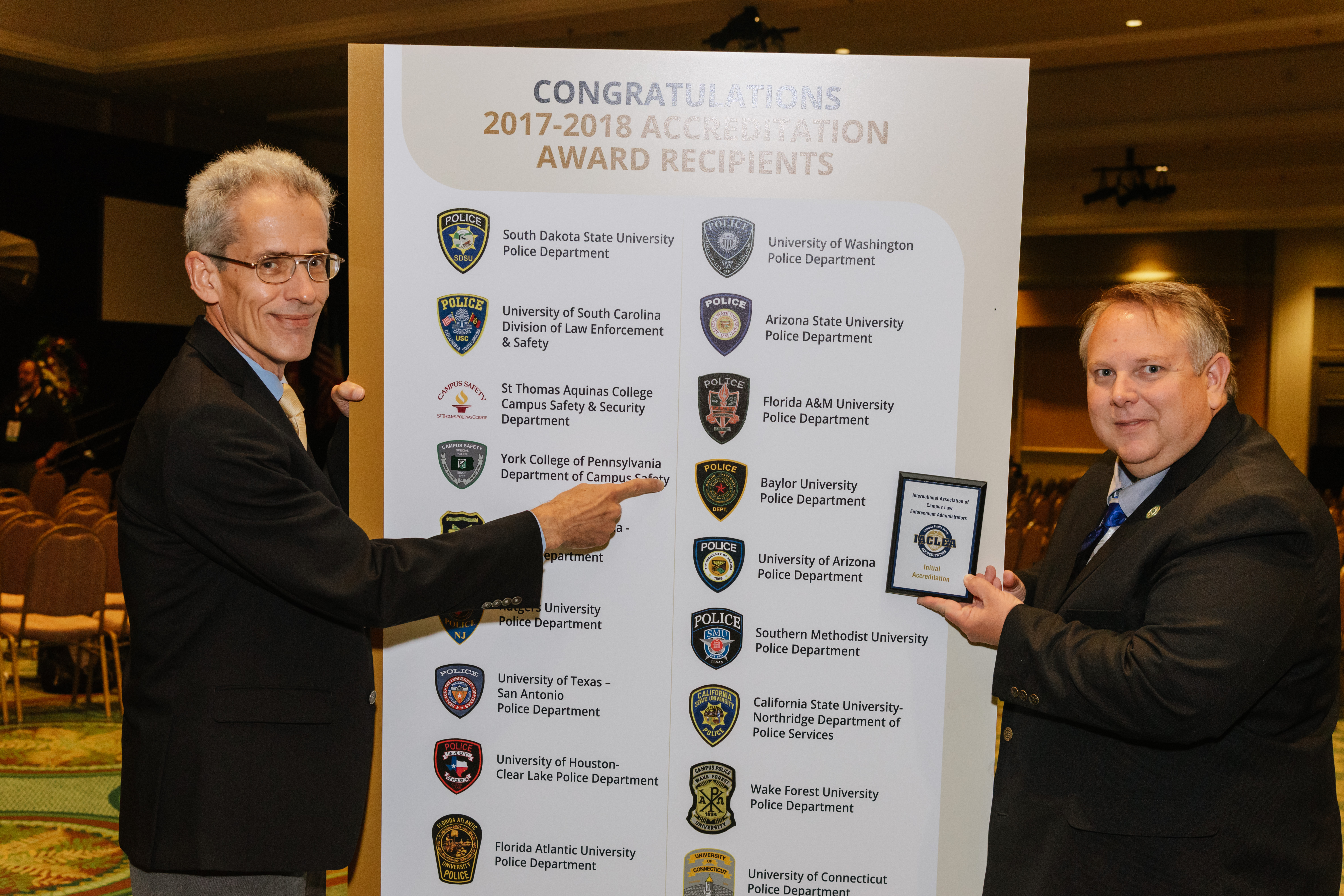 Baylor University Chief of Police Brad Wigtil and Accreditation Manager Sgt. Andrew Huntington point out their achievement following the Awards Ceremony at the 2018 Annual Conference & Exposition. © Mike Ritter